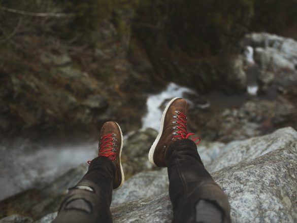 person sitting on rock cliff