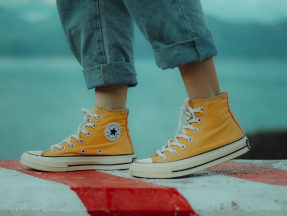 person wears yellow orange Converse All-Star high-top sneakers